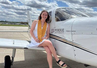 Chapter member sitting on the wing of a small aircraft