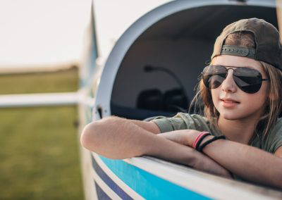 Young pilot leaning out the window of a small aircraft