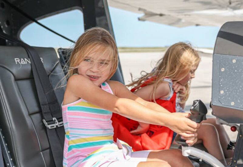 Two young girls at the controls of a small aircraft at Girls in Aviation Day