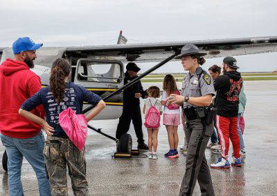 Families meet the crew beside a small aircraft