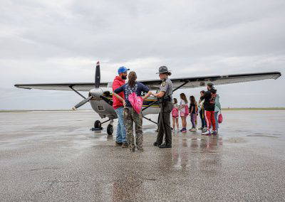 Visitors line up to see a small airplane on the ramp