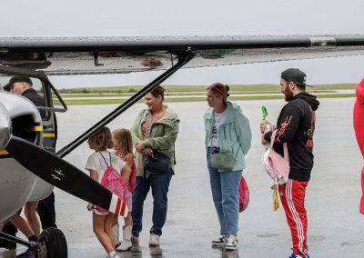 Families wait to look inside a small airplane