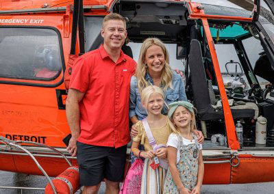 A family poses in front of the Coast Guard helicopter