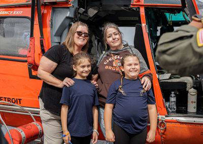 A mom and her daughters pose at the Coast Guard helicopter