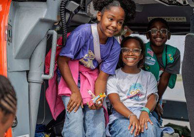 Two girls sit together in the Coast Guard helicopter doorway