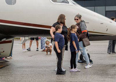 Families gather beside a business jet