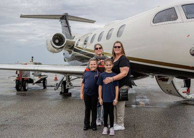 A family poses in front of a business jet