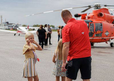 Girls run across the ramp toward the aircraft