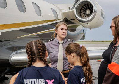 A pilot talks with girls in Future Pilot shirts