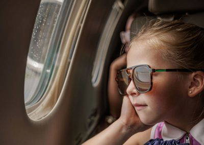 A girl relaxes by the window inside a business jet
