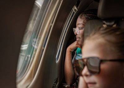Two girls look out the jet's cabin window