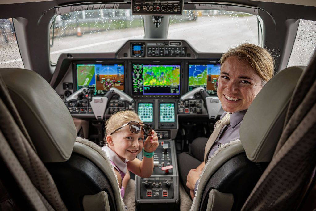 A girl in the copilot seat smiles back at the camera