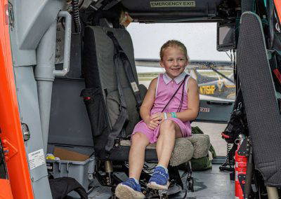 A girl sits in the Coast Guard helicopter seat