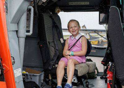 A girl smiles from a seat inside the Coast Guard helicopter