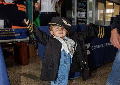 A little girl in a pilot jacket and cap