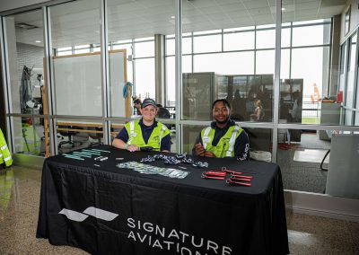 Signature Aviation volunteers greet visitors at their table