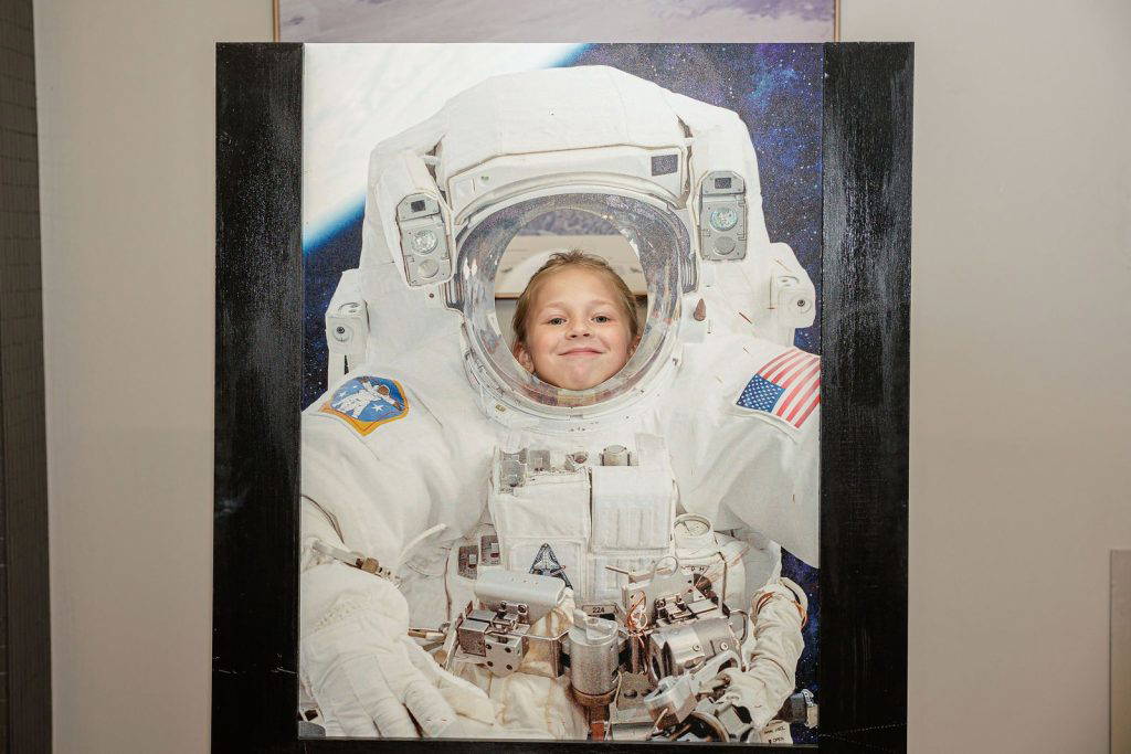 A girl poses in the astronaut photo cut-out