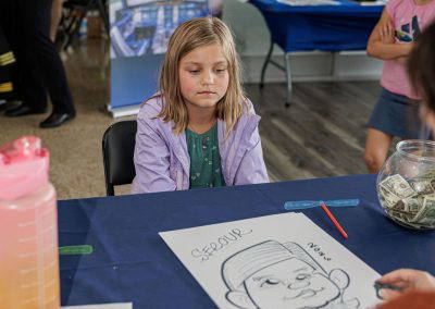 A girl colors at the Women in Aviation table