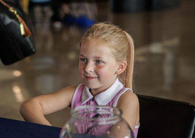 A girl smiles at the donation table