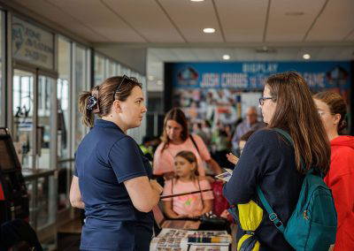 Volunteers talk with girls and parents at an activity table