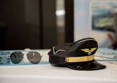 A pilot's cap and aviator sunglasses on a display table